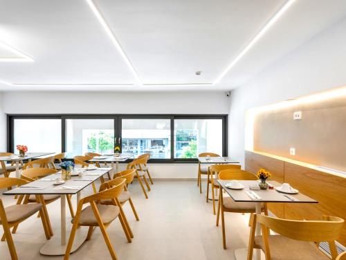 a dining room with tables and chairs and a chalkboard at DAYS City Suites in Patra