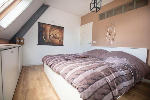 ファルケンスワールトにあるVakantiehuis De Drie Bruggenの毛布がかけられたベッドのある寝室