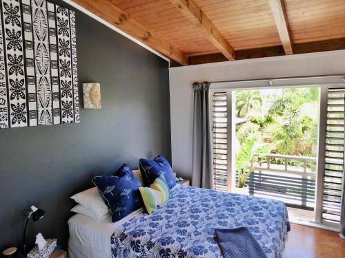 a bedroom with a bed and a large window at Muri Beachside Villa with pool in Rarotonga