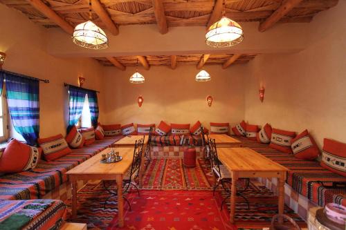 a large room with long tables and chairs at Maison d'Hôtes Agdal Telouet in Tiguidert