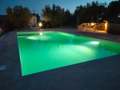 a swimming pool at night with green illumination at Agriturismo IL CANTINIERE in Grosseto