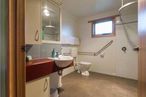 a bathroom with a sink and a toilet at ARTHUR RIVER LODGE - DOWN STREAM APARTMENT in Arthur River