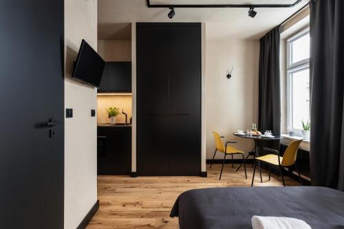 a bedroom with a black door and a table with chairs at Morning Light Sopot Apartment in Sopot