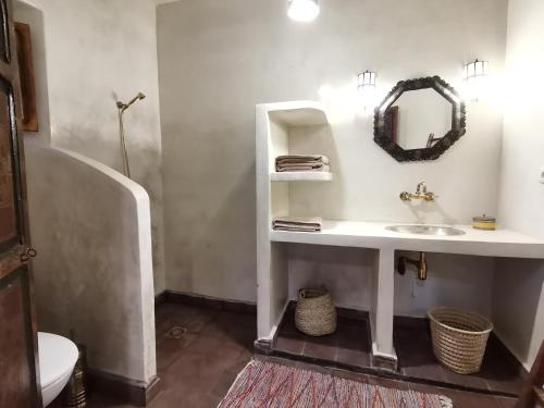 W łazience znajduje się umywalka i lustro. w obiekcie Les Jardins de Taja w mieście Ourika