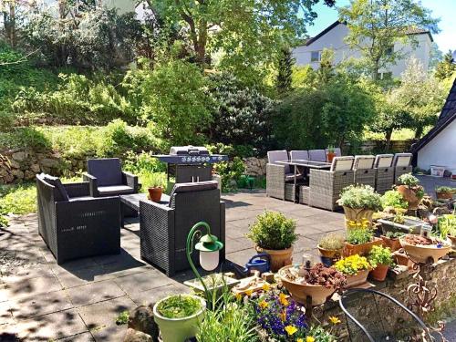 a garden with chairs and potted plants on a patio at Burg Maisonette im Posthalterhof mit Sauna in Blankenheim