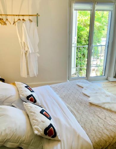 a bedroom with a bed with pillows and a window at Le 9 en Cuisine in Rabastens