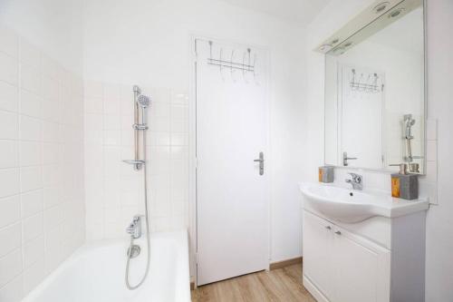 a white bathroom with a sink and a shower at Charmant T1 au cœur du centre historique de Dinan in Dinan