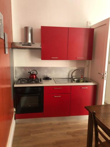 a red kitchen with a stove and red cabinets at La Terrazza in Marsala