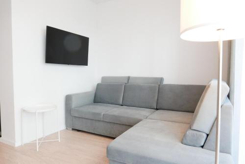a living room with a couch and a tv at Apartamenty Marco Polo in Dziwnówek