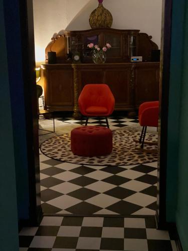 a room with a red chair and a checkerboard floor at SmartHotel Mystique Self check-in in Bad Homburg vor der Höhe