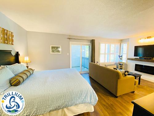 a bedroom with a large bed and a yellow couch at Slopeside Blue Mountain Condo - Wifi, Linens/Towels, Ski In/Out in Blue Mountains
