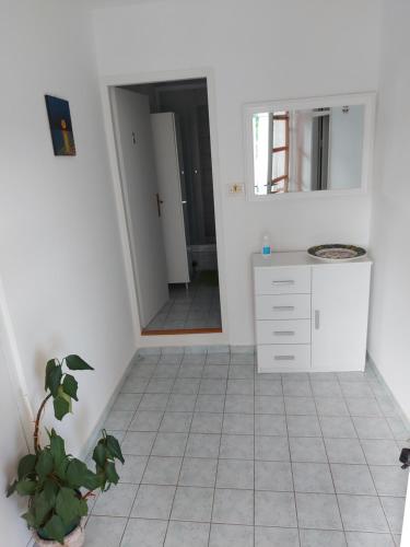 een witte badkamer met een wastafel en een spiegel bij Apartment Nika in Šibenik