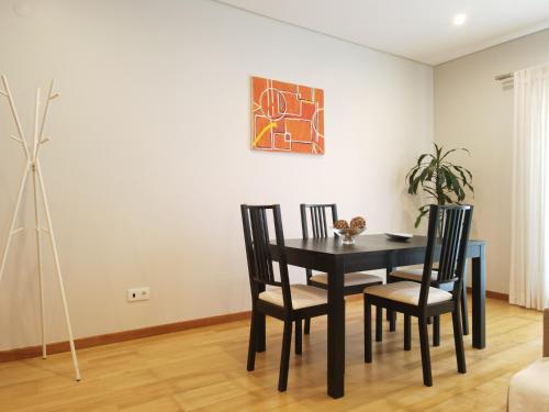 a dining room with a black table and chairs at AzorRelax City in Ponta Delgada