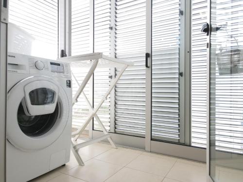 a washing machine in a room with blinds at AzorRelax City in Ponta Delgada