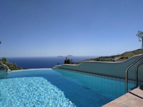 uma piscina com escorrega junto ao oceano em Alexena Apartments em Agía Galíni
