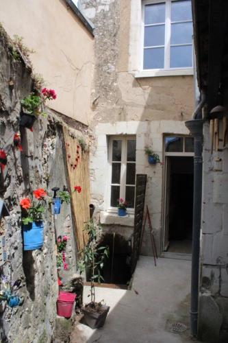 a building with flowers on the side of it at Gîte du fil, Le Lude in Le Lude