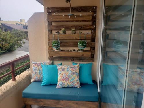 un banco en un balcón con almohadas azules en el Departamento en Reñaca ARRIENDO, en Viña del Mar