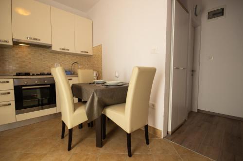 a kitchen with a table and chairs in a room at zdenka in Rabac
