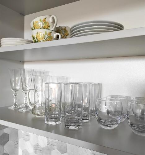 a row of glasses sitting on a shelf at VIEW 20 APARTAMENT in Giżycko