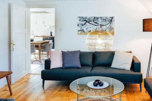 ein Wohnzimmer mit einem blauen Sofa und einem Glastisch in der Unterkunft Apartment Aussee- Hallsatt Salzherrenhof- Küche, WLAN, Netflix in Bad Aussee