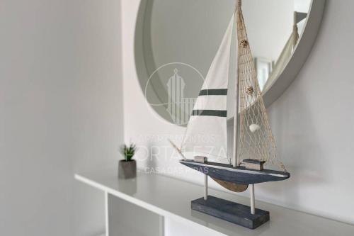 una barca a vela in miniatura su uno scaffale in una stanza di Casa das Ripas (central and less than 200m from the beach) a Sesimbra