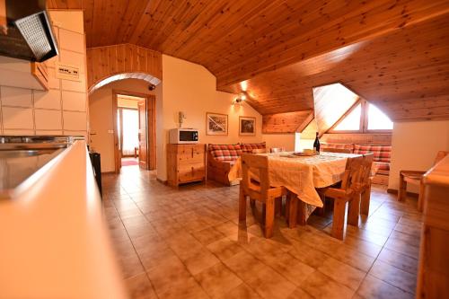a kitchen and dining room with a table and chairs at Residence Raethia tra Bormio e Livigno in Valdidentro