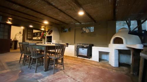 Una cocina con mesa y sillas y un horno. en Casa incrível na beira do rio Caraíva, en Caraíva