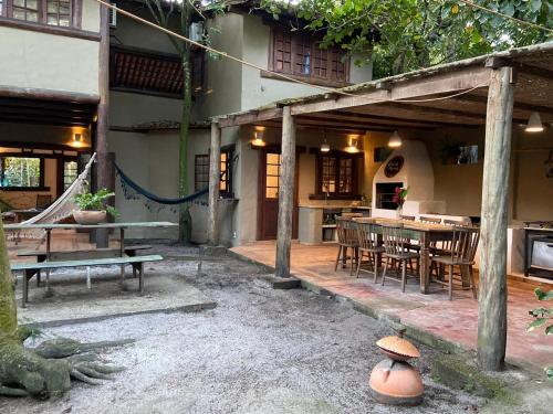 Un patio con mesa y sillas y una casa. en Casa incrível na beira do rio Caraíva, en Caraíva
