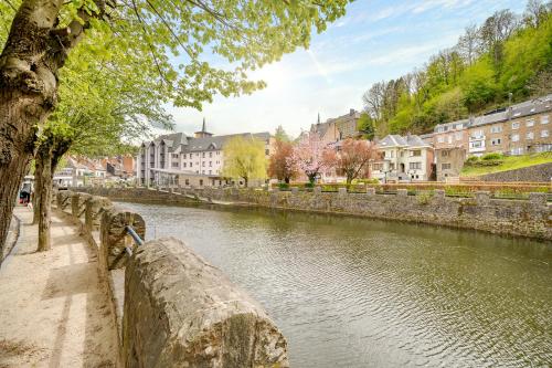 a river in a city with buildings in the background at Quai de l'Ourthe Floor1-2 in La Roche-en-Ardenne