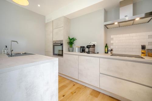 a kitchen with white cabinets and a counter top at Quai de l'Ourthe Floor1-2 in La Roche-en-Ardenne