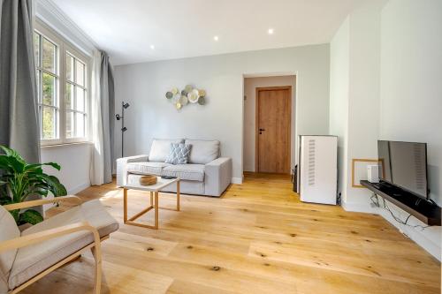 a living room with a white couch and a television at Quai de l'Ourthe Floor1-2 in La Roche-en-Ardenne