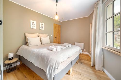 a bedroom with a large bed with towels on it at Quai de l'Ourthe Floor1-2 in La Roche-en-Ardenne