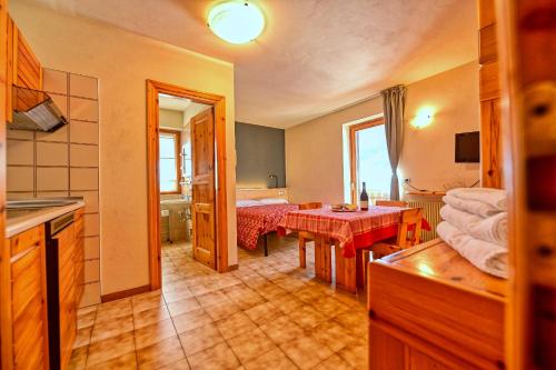a room with a kitchen and a dining room at Residence Raethia tra Bormio e Livigno in Valdidentro