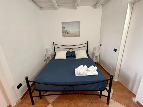 ランペドゥーザにあるAppartamenti Terranovaのベッドルーム1室(ブルーベッド1台、タオル2枚付)