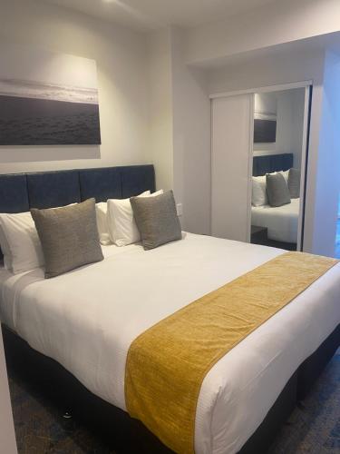 a bedroom with a large white bed with pillows at Ramada by Wyndham Wellington Taranaki Street in Wellington