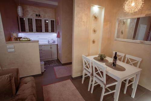 a kitchen with a white table and chairs in a room at Studio apartman Dona in Nova Varoš
