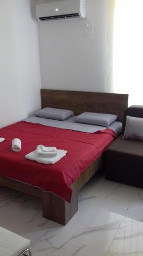 a bedroom with a bed with a red blanket and a chair at Apartman Markovic Silver Lake in Veliko Gradište