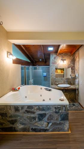 a large bathroom with a large tub in a room at Posada del Sauce in Villa General Belgrano