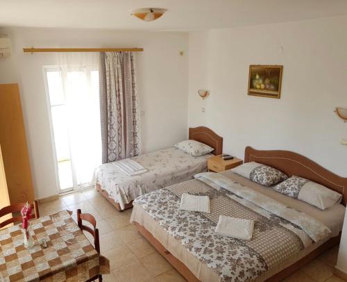 1 dormitorio con 2 camas y ventana en Guesthouse Domenik en Ulcinj