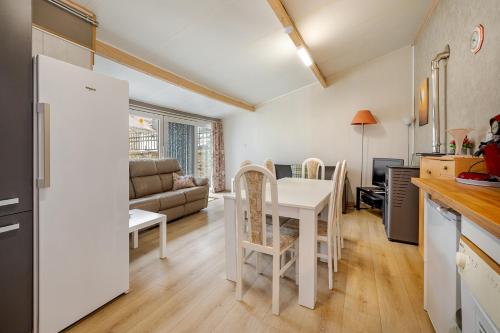 a kitchen and living room with a table and chairs at Le préau, honden vriendelijke huisje in Ardennen in La Roche-en-Ardenne