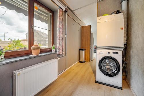 a washer and dryer in a room with a window at Le préau, honden vriendelijke huisje in Ardennen in La Roche-en-Ardenne