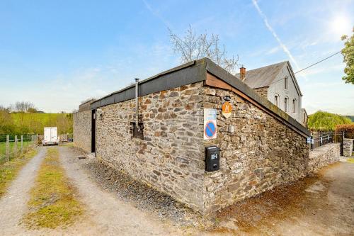a stone building with a sign on the side of it at Le préau, honden vriendelijke huisje in Ardennen in La Roche-en-Ardenne