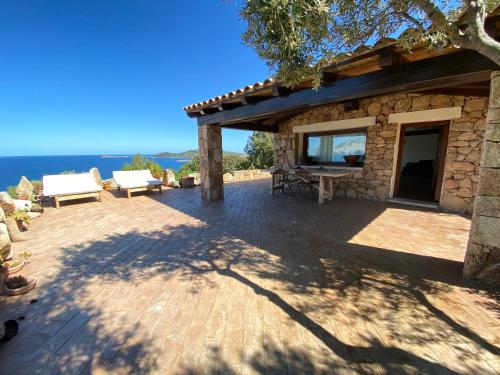 a stone house with a view of the ocean at Villa Rubia - Belocations in Monte Petrosu