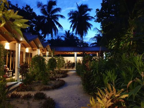 a resort with palm trees and a building at Thoddoo Beach Holiday in Thoddoo