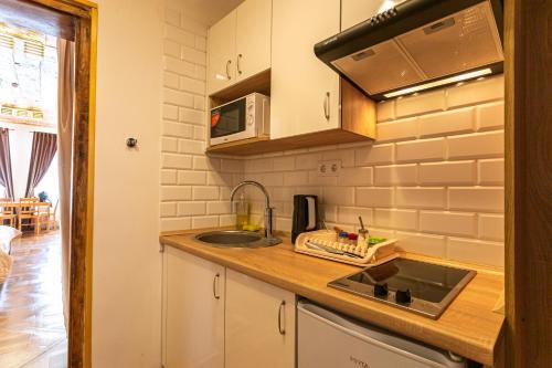 a kitchen with a sink and a microwave at Luxury apartment with Rynok square view in Lviv