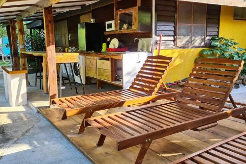 a kitchen with two wooden chairs in a kitchen at Pension Les Trois Cascades in Uturoa