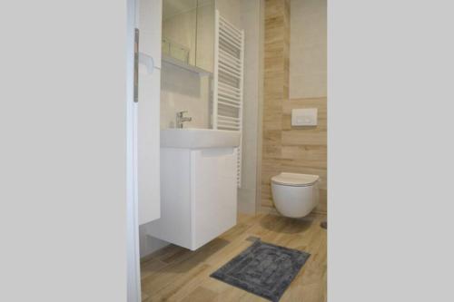 uma casa de banho com um lavatório branco e um WC. em Comfy New Apartment em Sarajevo