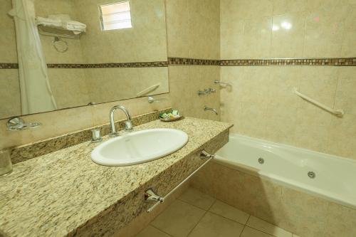 y baño con lavabo y bañera. en Apart Hotel Ayres De Termas en Termas de Río Hondo
