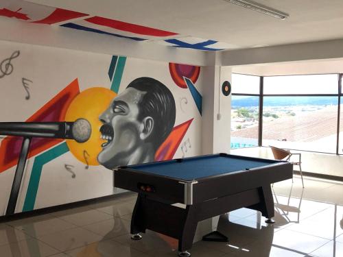 a ping pong table in a room with a mural at Hotel del Paseo in San José