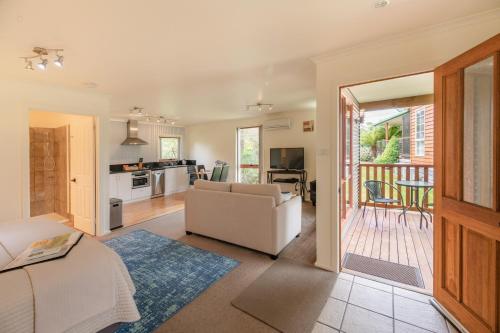 a living room with a couch and a kitchen at Aloft Boutique Accommodation in Strahan